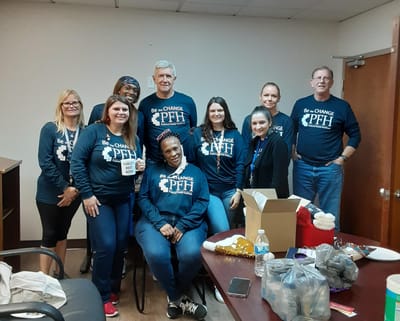 Staff members posing together in a common area