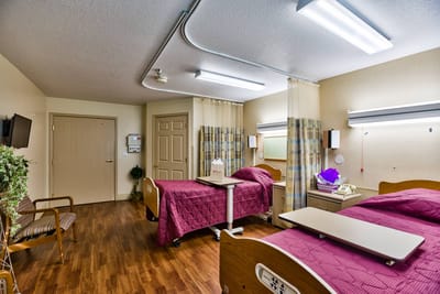A shared resident room with two beds and a hospital-style setup