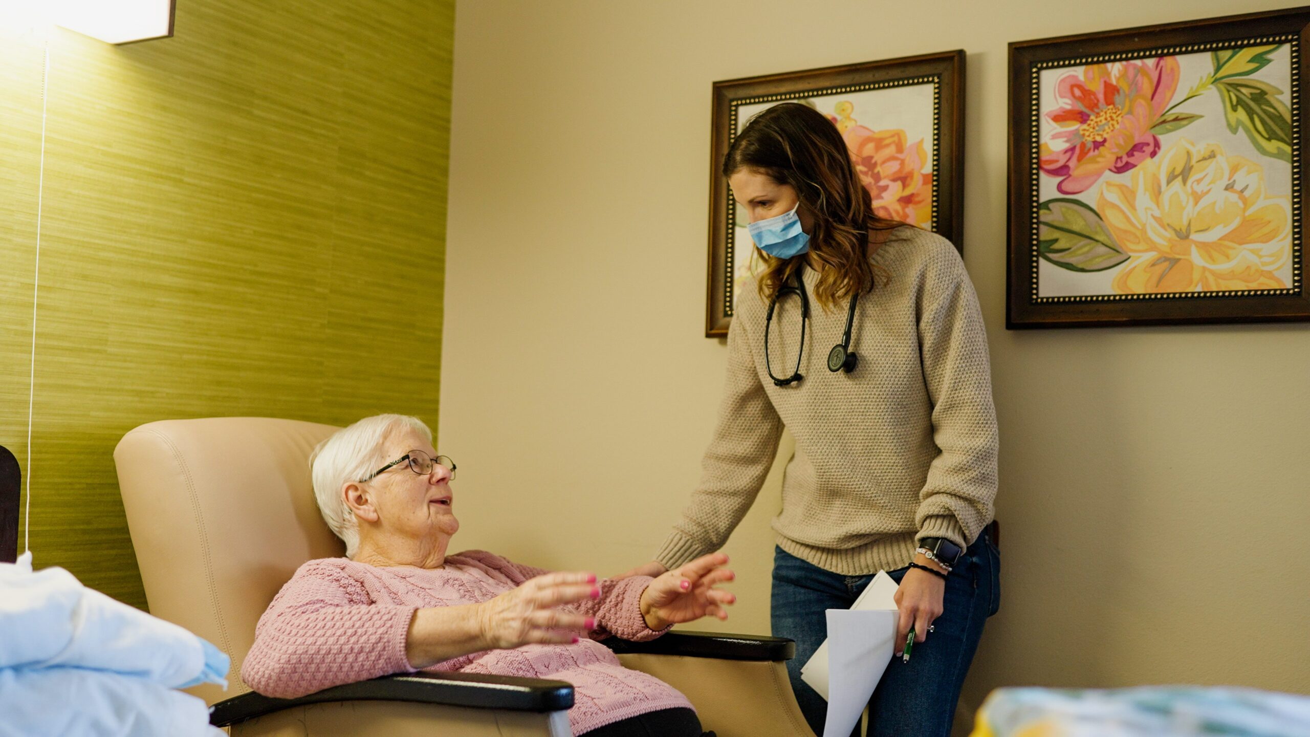 Nurse interacting with a resident in a warm interior setting