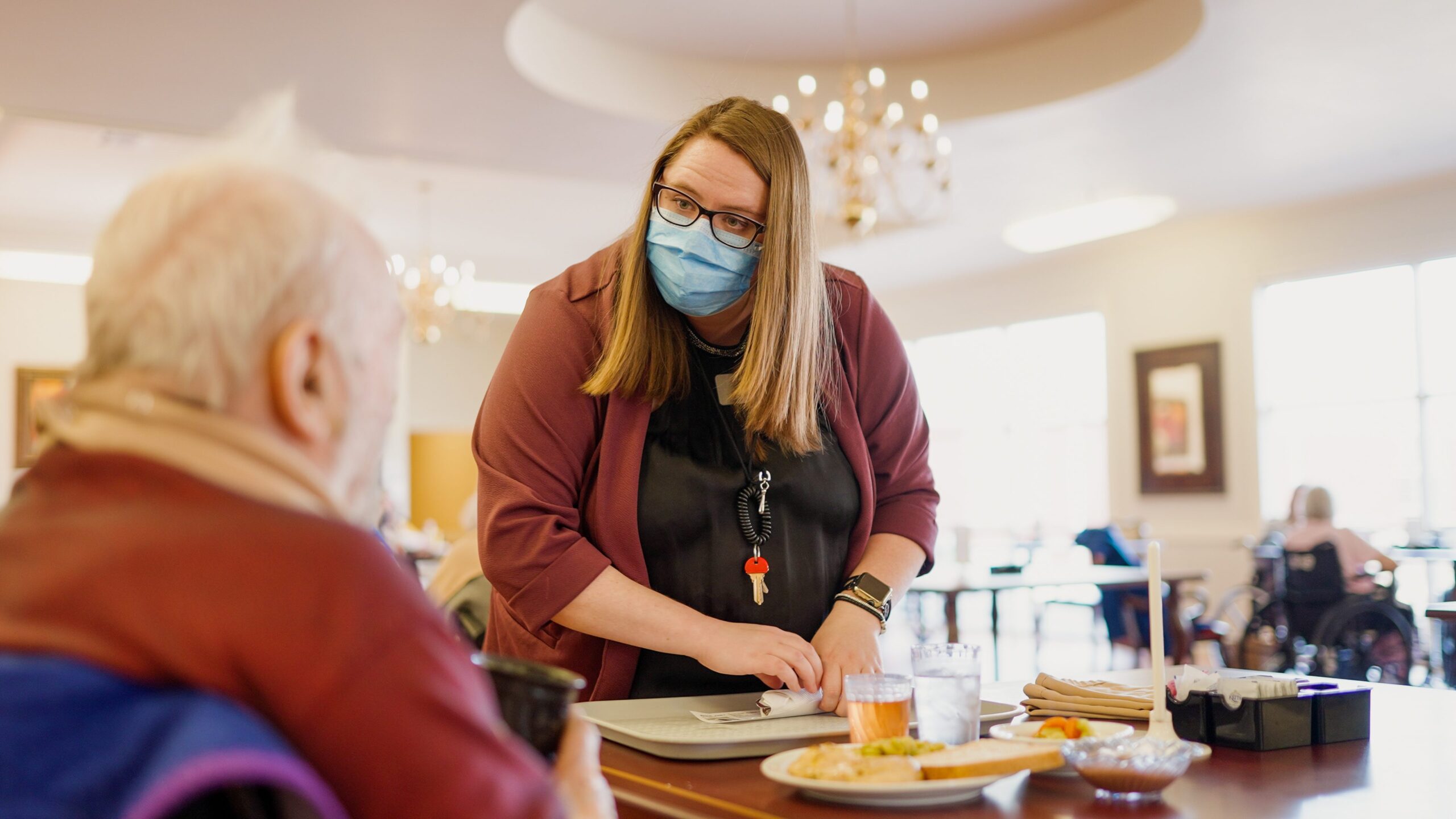 Staff member serving food to a resident in the dining room