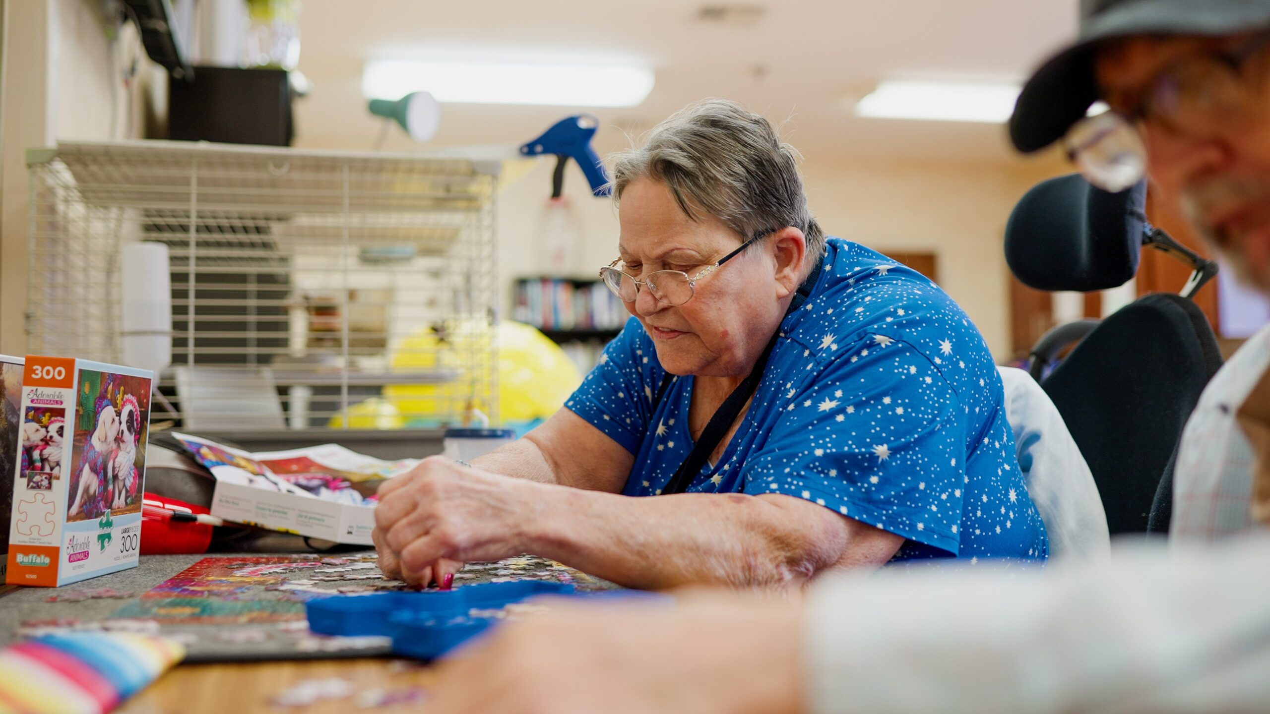 Residents engaged in a puzzle activity at a common table