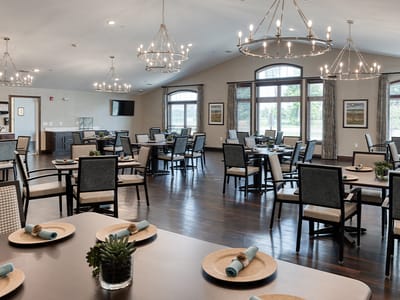 Dining area with tables and chairs, well-lit and spacious