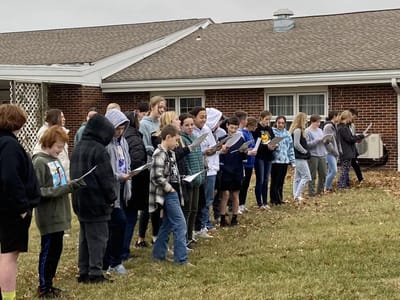 Group of people singing outside the facility