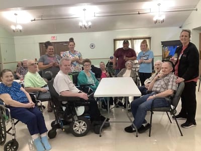 Residents and staff gathered in a bright activity room