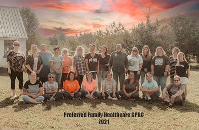 Staff gathering outdoors with a beautiful sunset.