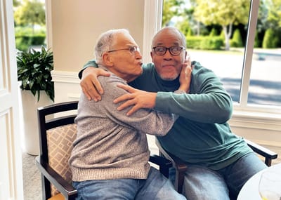 Two residents sharing a joyful moment in the common area