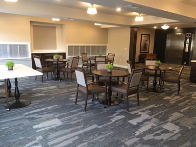 Common area with tables and chairs in a bright setting