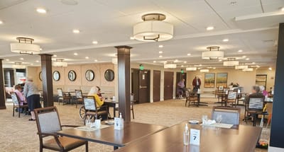 Interior dining area with residents and staff interacting