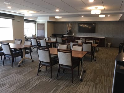 Bright common area with large windows and multiple tables
