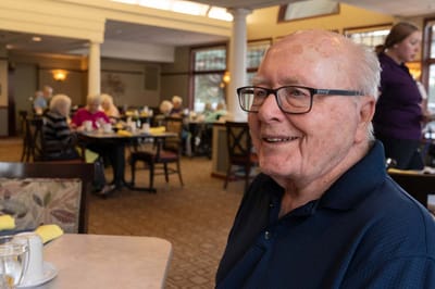 Happy resident enjoying a meal in the dining room