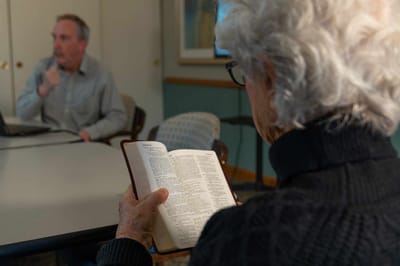 Senior resident reading a book in a common area