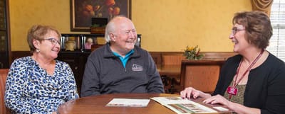 Residents and staff engaged in conversation at a table