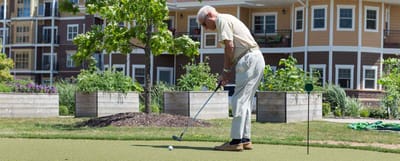Resident playing golf in an outdoor green space