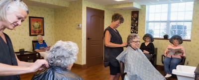 Residents enjoying a salon activity with staff assistance