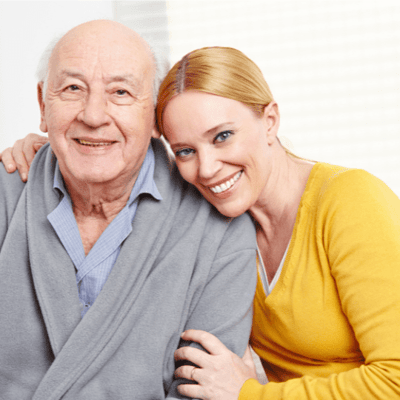 Smiling elderly man with caregiver in a bright room