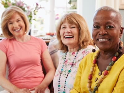 Three happy residents smiling in a bright common area