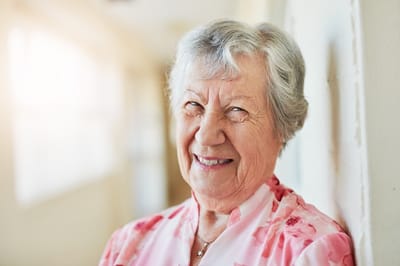 A smiling elderly woman in a hallway