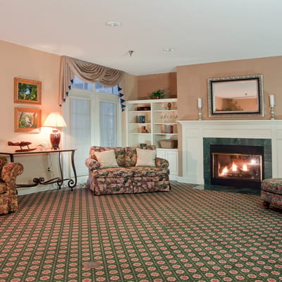Cozy common area with a fireplace and floral couches