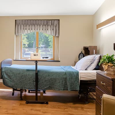 A cozy resident room with a bed and natural light