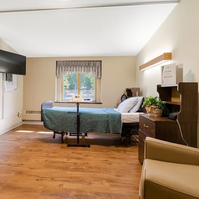 A private resident room with a bed and seating area