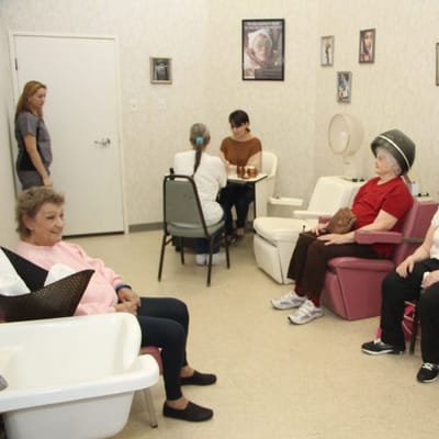 Residents enjoying a salon activity in a common room.