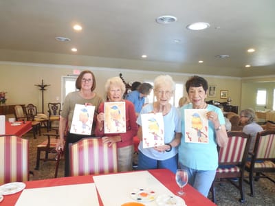 Residents participate in an art activity displaying their artwork.