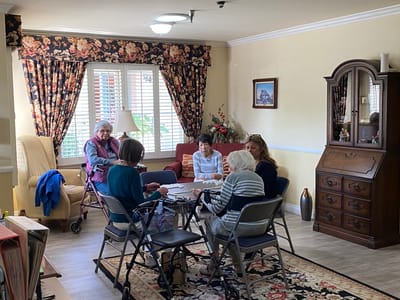 Residents engaging in a card game in the common area.