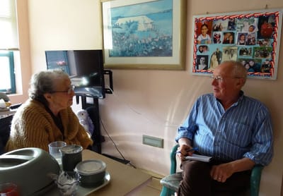 Senior resident conversing with staff member.