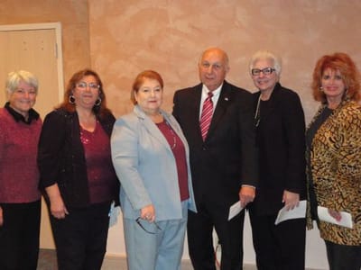 Group of people posing together at an event.