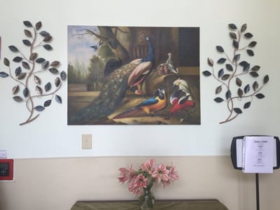 Decorative wall art with peacocks and flowers.