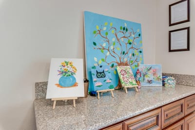 Colorful paintings displayed on a countertop.