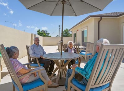 Residents enjoying time outdoors under an umbrella