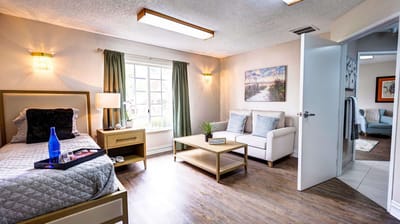Brightly lit resident room with furniture and decor.