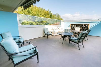 Outdoor seating area with blue walls and trees