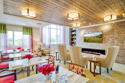 Bright common area with comfortable seating and flowers.