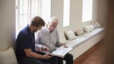 Two men engaged in a discussion in a comfortable interior.