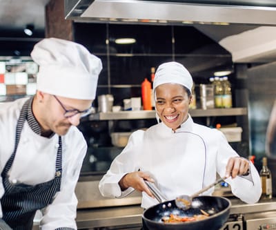 Two chefs preparing a meal in a kitchen