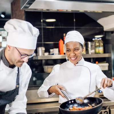 Two chefs preparing a meal in a kitchen.