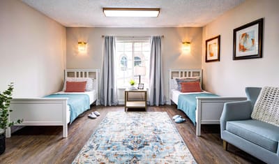 Bright resident room with twin beds and decor