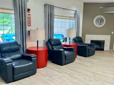 Seating area with recliners and lamps in a common room.