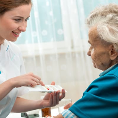 Staff assisting an elderly resident with care.