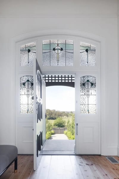 Welcoming entrance with stained glass and open door.
