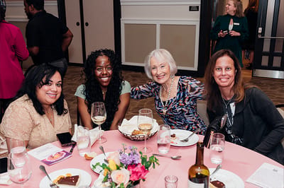 Residents enjoying a meal and company at a dining table.