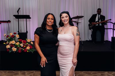 Two women posing at a celebration event.