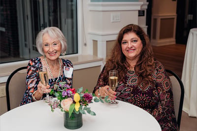 Two women enjoying drinks in a common area.