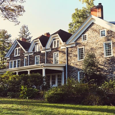 Exterior view of a stone building surrounded by greenery.