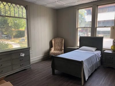 A private room with a bed and chair.