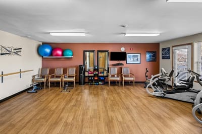 Interior fitness room with exercise equipment and seating.