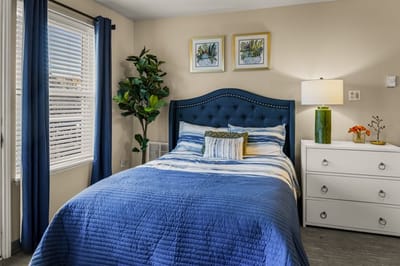 A well-furnished resident room with blue decor.