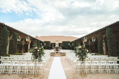 Outdoor event space with floral decorations and seating.